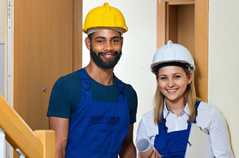 Professional maintenance  young crew of two in helmets indoors