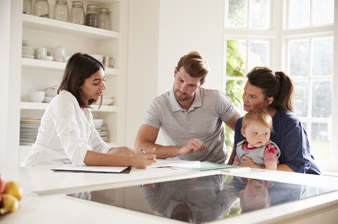 Family With Baby Meeting Financial Advisor At Home